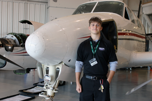 Ryan Sapp poses with an airplane in a hanger on MGA's Eastman Campus-based School of Aviation.